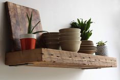 some pots and plants are sitting on a shelf