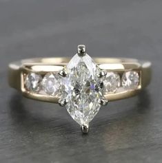 an engagement ring with a pear shaped diamond in the center and side stones on each band