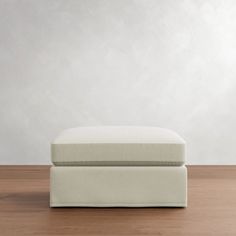 a white ottoman sitting on top of a wooden floor