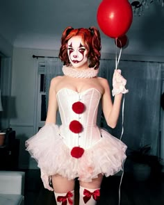 a woman dressed up as a clown holding a red balloon and wearing a white corset