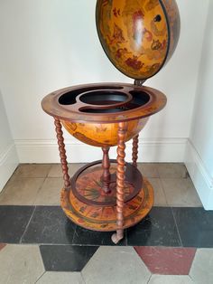 an old fashioned wooden table with a globe on top