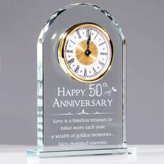 a glass clock with the words happy 50th anniversary written in gold and white on it