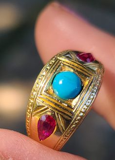 14K yellow gold vintage ring with a round natural Turquoise in the center flanked by two pear shaped lab created Rubies. The color combination of the stones and the yellow gold is lovely and quite striking. There are engravings along the edges of the ring and framing the center Turquoise. Engraved on the Inside of the ring are the initials M.H. There are no other hallmarks, gold purity tested and guaranteed 14K. Size 7 US   In very good vintage condition commensurate its vintage age. Luxury Gold Turquoise Ring In Vintage Style, Gold Vintage Ring, Champagne Diamond Rings, Star Bracelet, Champagne Diamond, Ruby Ring, Vintage Ring, Natural Turquoise, Color Combination