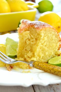 a piece of cake on a plate with a fork and some lemons next to it