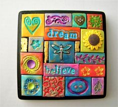 a colorful tile with the words dream believe and sunflowers in different colors on it