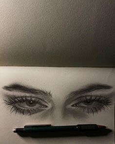 a pencil drawing of an eye with long lashes and eyeshades on the paper