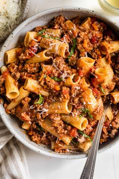 a white bowl filled with pasta and meat