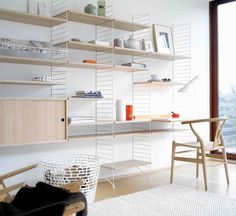 a living room filled with lots of furniture and bookshelves next to a window