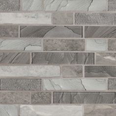 a gray and white tile wall with different shades of grey tiles on the bottom half