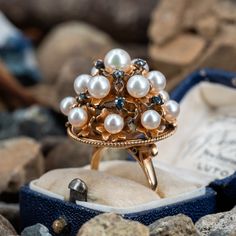 This captivating vintage cocktail style ring features a domed pierced gallery accented with fifteen (15), post set, cultured saltwater pearls and nine (9), prong set, round mixed cut natural sapphires. The ring measures 23.9mm at the top, rises 21.0mm above the finger, tapering to 2.0mm wide and 0.7mm thick at the base of the shank. This ring is currently a size 8. Vintage Multi-stone Pearl Ring For Anniversary, Vintage Multi-stone Sapphire Wedding Ring, Vintage Multi-stone Pearl Ring For Formal Occasions, Vintage Multi-stone Pearl Ring For Formal Events, Vintage Cluster Sapphire Ring For Wedding, Vintage Cluster Sapphire Wedding Ring, Heirloom Multi-stone Pearl Ring For Wedding, Heirloom Multi-stone Pearl Wedding Ring, Saltwater Pearls