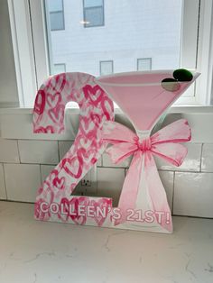 the number twenty two is decorated in pink and white with a large bow on it