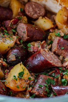 cooked sausage and potatoes in a bowl with parsley on the top, ready to be eaten