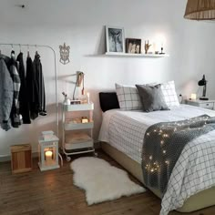 a bedroom with white walls and wood flooring is decorated in neutral tones, including black and white bedding