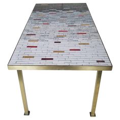 a white table with red and gold tiles on the top, sitting in front of a white background