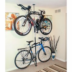 two bikes are mounted to the wall in a room with carpeting and rugs