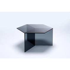 a black glass table with an angled top on a white background in front of the camera