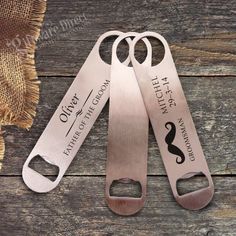 three personalized bottle openers are shown on a wooden table with burlocks