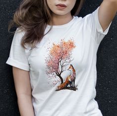 Show off your unique style with this Japanese-inspired watercolor t-shirt! Featuring a playful cartoon fox and sakura (cherry blossoms) design, this vibrant shirt is sure to turn heads. Printed on high-quality cotton, this tee is sure to become a favorite in your wardrobe. Mi-approved! 🌟 UNISEX T-SHIRT deets: 🌟 💯% ring-spun cotton 😍 Fabric weight: 4.2 oz/y² (142 g/m²) 🏋️♀️ Shoulder-to-shoulder taping for added comfort 🤗 Dual side seams keep the garment's shape longer! 🔄 🌀 WASHING & CARE instructions 🌀 Machine wash cold 🥶, inside-out, on a gentle cycle with mild detergent and similar colors. Use non-chlorine bleach only when needed 🌈. Skip the fabric softeners, please! Tumble dry low or hang-dry for maximum life 🌬️. Cool iron inside-out if required, but keep it away from the dec Floral Shirt Aesthetic, Cottage Core Clothing, Fox T Shirt, Sakura Design, Fox Shirt, Cottagecore Shirt, Aesthetic Shirt, Shirt Aesthetic, Sakura Cherry Blossom