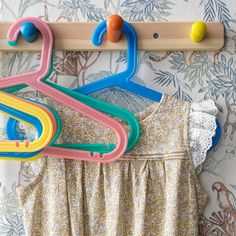 colorful clothes hangers are hanging on a wall