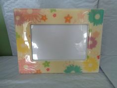 a flowered photo frame sitting on top of a white sheet