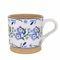 a blue and yellow flowered coffee cup on a white background with brown rims