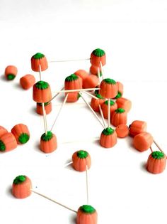 carrots are arranged on sticks and placed in the shape of a structure with green leaves