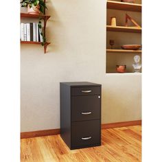 a filing cabinet sitting on top of a hard wood floor next to a book shelf