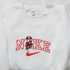 Introducing the Candy Cane x Nike Embroidered Sweatshirt, a festive fusion of comfort and style. This limited edition collaboration features a striking candy cane embroidery on a premium Nike sweatshirt. Made with high-quality materials, this sweatshirt guarantees supreme comfort and durability. The Nike Inspired Embroidered Shirt is a must-have for any sneakerhead. With its unique Nike-inspired embroidery, this shirt effortlessly combines fashion and sport. Crafted from soft and breathable fabr Nike Box Christmas Tree, Rhinestone Nike Sweatshirt, Nike Sweatshirts Svg, Strawberry Nike Sweatshirt, Cute Sweat Shirt Nike, Candy Cane Nike Sweatshirt, Astetic Nike Sweatshirt, Custom Nike Sweatshirt Christmas, Nike Christmas Svg