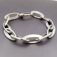 14k White Gold Open Link Bracelet - Modern Design Heavy Large Links  Made in Italy - ET207 Measures 8", but due to thickness of the links, this comfortably fits a woman's medium size wrist  (6.75" - 7") Metal Content: Solid 14k White Gold Clasp: Integrated Lobster Clasp Length:  8" (see above) Width:  3/8" (10mm) Weight: 16 Grams Marked: Chiampeson, Italy, 14kt Condition: Pre-Owned Each piece is thoroughly examined and refinished as needed by our professional jewelers, tested to guarantee metal content,  graded by our in-house GIA (Gemological Institute of America) Graduate Gemologist, and inspected for quality before being carefully packaged and promptly shipped. Thank you for taking the time to shop with us! We have hundreds of more listings, with more being added every week! From neckla Modern Hallmarked Oval Link Jewelry, Modern Gold Bracelet With Oval Link, Classic Hallmarked Oval Link Chain Bracelet, Modern Oval Link Chain Bracelet With Bracelet Strap, Modern Chain Bracelet With Oval Links, Modern Link Jewelry With Hallmark, Modern Sterling Silver Bracelet With Oval Link Oyster, Modern Jubilee Chain Bracelet With Oval Links, Bracelets And Charms