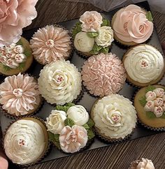 there are many cupcakes in the box on the table and one is decorated with flowers