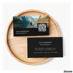 a wooden plate with a business card on it next to a wood platter that has an image of a person standing in the water