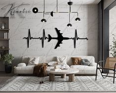 a living room filled with furniture and a wall mounted to the side of it that has an airplane stencil on it