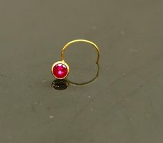 18 kt or 18 carat yellow gold handmade excellent single stone nose L band nose stud. Fabulous red color stone looking  pretty, excellent  bridesmaid , customized personalized jewelry from india.Metal-18 kt yellow gold.Item type-nose pin.Weight-0.060 grams.size-3.5 mm approx(top with stone)Closure- U band.Makes excellent gifting for birthday,mother's day. valentines day, Christmas day, wedding anniversary. Red Stone Jewelry, Nose Pin, Nose Jewelry, Nose Ring Stud, Single Stone, Nose Stud, Color Stone, Body Jewellery, Design Silver