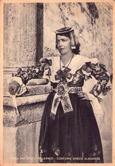 an old black and white photo of a woman wearing a dress with flowers on it