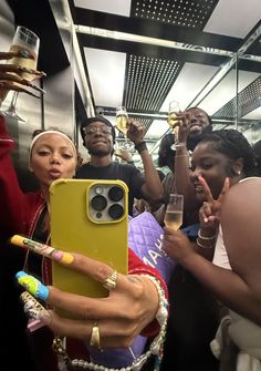 a group of people on a bus holding up their cell phones and pointing at them