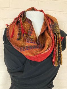 Each of my scarves is hand-dyed, hand-woven and one of a kind. I start with pure silk, then dye it, warp it, and weave it. The silk is exceptionally soft to the touch, with an elegant soft drape.  My scarves are lightweight, breathable, yet warm. They can be worn fall, winter, and spring and even on cool summer evenings.  They are finely woven, yet durable and long-lasting. They can be washed easily by hand with mild soap and warm water, or dry-cleaned. Handwoven Folk Shawl One Size, Folk Style Handwoven Shawl, Traditional Woven Shawl For Fall, Folk Style Red Shawl For Festival, Red Folk Shawl For Festivals, Festival Handwoven Shawl One Size, Handwoven Festival Shawl, One Size, Bohemian Shawl With Weaving Work For Festival, Bohemian Woven Shawl For Festival