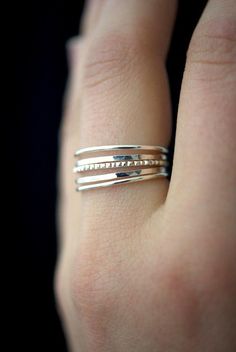 a woman's hand with two silver rings on top of her finger and the ring is