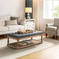 a living room filled with furniture and a lamp on top of a wooden coffee table