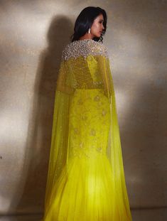 Yellow power shoulder crop featuring hand-embellished ivory camellia flowers paired with a tiered georgette lehenga and embellished waistband with ivory drops & a ruffled dupatta.From Shloka Khialani's Winter Sun collection.DELIVERY TIMEPlease allow 6-8 weeks for your outfit to arrive.FABRIC DETAILSGeorgette, NetProfessional cleaning only. Glamorous Designer Organza Dresses, Embellished Organza Gown With Cape Sleeves, Hand Embellished Gown With Cape Sleeves For Reception, Wedding Dresses With Cape Sleeves For Party, Wedding Party Dresses With Cape Sleeves, Glamorous Organza Gown With Dupatta, Organza Gown With Sheer Dupatta And Cape Sleeves, Yellow Hand Embellished Dress For Reception, Cape Sleeves Hand Embellished Dupatta For Reception