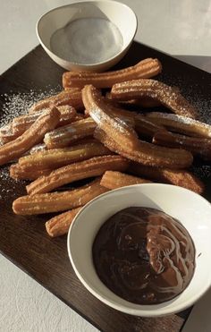 churros and dipping sauce on a wooden tray