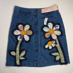 Floral Applique Denim Pencil Skirt - Size 12 This Stunning Denim Pencil Skirt Has Been Transformed Into A Romantic, One-Of-A-Kind Piece With Beautiful Floral Appliques! Starting With A New Old Navy Jean Skirt In A Women's Size 12, It Has Been Given A Makeover With Lovely Handcrafted Details. Designed With Fabrics A Variety Of Colors Patches With A Frayed Denim Patch Background. Check Out The Little Jacquard Trim Patch On The Waistband. Details: Faux Flap Pockets Button Front 100% Cotton Exclusiv Spring Denim Patchwork Skirt, Spring Denim Blue Patchwork Denim Skirt, Spring Denim Skirt With Patchwork, Spring Denim Blue Skirt With Patchwork, Spring Blue Patchwork Denim Skirt, Blue Patchwork Denim Skirt For Spring, Trendy Patchwork Denim Skirt For Spring, Spring Blue Patchwork Skirt, Spring Medium Wash Patchwork Skirt