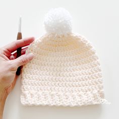 the crochet hat is being worked on by someone using scissors to make it