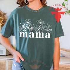 Wildflowers Mama Comfort Colors® Shirt, Floral Mama Shirt, Gift for Mom, Mothers Day Gift, Flower Mama Tee, Best Ever Mom Tee, Blossom Tee  These are unisex cut, true to size, and Relaxed Fit Comfort Colors brand t-shirts. Materials & Features: Double-needle armhole, sleeve and bottom hems 7/8" double-needle topstitched collar Signature twill label Garment-dyed ring spun fabric Twill taped neck and shoulders for extra durability Relaxed fit tubular body Our garments are pre-shrunk during the gar Mother's Day Floral Print Short Sleeve Top, Floral Print Short Sleeve Top For Mother's Day, Floral Print Short Sleeve Top, Green Short Sleeve T-shirt For Mother's Day, Mother's Day Green Short Sleeve T-shirt, Green Letter Print Shirt For Spring, Floral Print Flower-shaped Tops For Mother's Day, Mother's Day Floral Print Relaxed Fit T-shirt, Mother's Day Floral Print Cotton Shirt