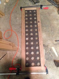 a metal grate sitting on top of a floor next to some wood planks