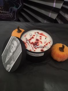 two donuts with blood on them sitting next to an orange and black clock that says it's halloween