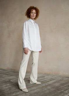 The white oversized button-down shirt Seconda is a timeless wardrobe essential that offers versatility, making it a perfect choice for any occasion. Whether it's a business meeting or a relaxing day, Seconda ensures your comfort with its organic cotton fabric and oversize design. This shirt offers a sense of sophistication and high-quality craftsmanship that you can truly feel when you wear it.Features: Oversized dropped shoulder design Classic collar split in two at the back 3-buttoned cuffs Cu Timeless White Button-up Blouse, Timeless Relaxed Fit Workwear Shirt, Timeless Relaxed Fit Shirt For Work, Timeless White Blouse For Work, Elegant Oversized Cotton Shirt, Elegant Oversized Business Casual Blouse, Elegant Oversized Shirt For Work, Elegant Oversized Blouse For Business Casual, White Button-up Dress Shirt For Work