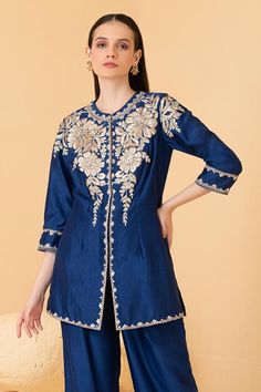 Blue chanderi long top featuring zari embroidered floral motifs embellished with sequins. Comes with palazzo.
Components: 2
Pattern: Embroidered
Type Of Work: Zari, Pearl, Sequin
Neckline: Mandarin Collar
Sleeve Type: Three quarter
Fabric: Chanderi
Color: Blue
Other Details: 
Attached lining
Length: Top sleeve: 18 inches
Weight: 1.5 kgs
Closure: Long Top: Hook
Occasion: Cocktail,Reception - Aza Fashions Long Sleeve Salwar Kameez With Floral Embroidery For Reception, Diwali Semi-stitched Resham Embroidered Top, Floral Embroidered Long Sleeve Salwar Kameez For Reception, Long Sleeve Floral Embroidered Salwar Kameez For Reception, Bollywood Style Embellished Chanderi Kurta, Embellished Straight Kurta For Festivals, Festivals Embellished Chanderi Kurta, Embellished Chanderi Kurta For Festivals, Embellished Chanderi Kurta For Eid