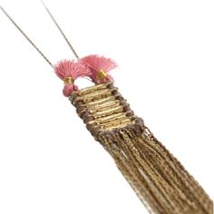 a pink and gold tassel hanging from a string