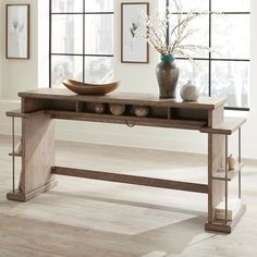 a wooden table with two vases on it and some rocks in front of the table