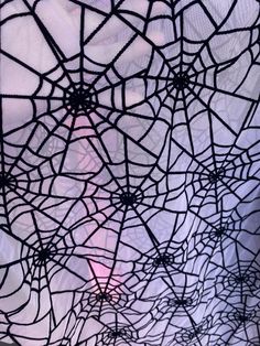 the inside of a spider web is shown in black and purple tones with an orange light behind it